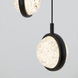 Close-up of two modern spherical pendant lights with textured white glass and black circular frames, suspended from the ceiling against a plain light gray background.