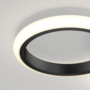A close-up of the Artika Nyala 15 in. LED flush mount light 5CCT, featuring a black ring and glowing white edge, installed on a light-colored ceiling.