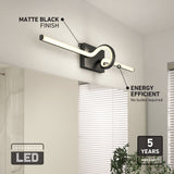 A modern matte black wall-mounted LED light fixture with a circular and linear design, labeled as energy efficient with a 5-year warranty. The background includes a window with blinds and a plant.