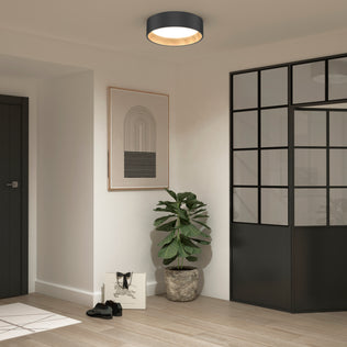 A modern entryway with light wood floors, black-framed glass doors, a potted plant, wall art, black shoes, a white bag, and the Alton LED flush mount by Artika for stylish contemporary lighting.