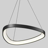 A modern, asymmetrical black pendant light hangs from the ceiling by three thin wires. The fixture has a smooth, curved shape with an inner glowing white light. The background is plain light gray.