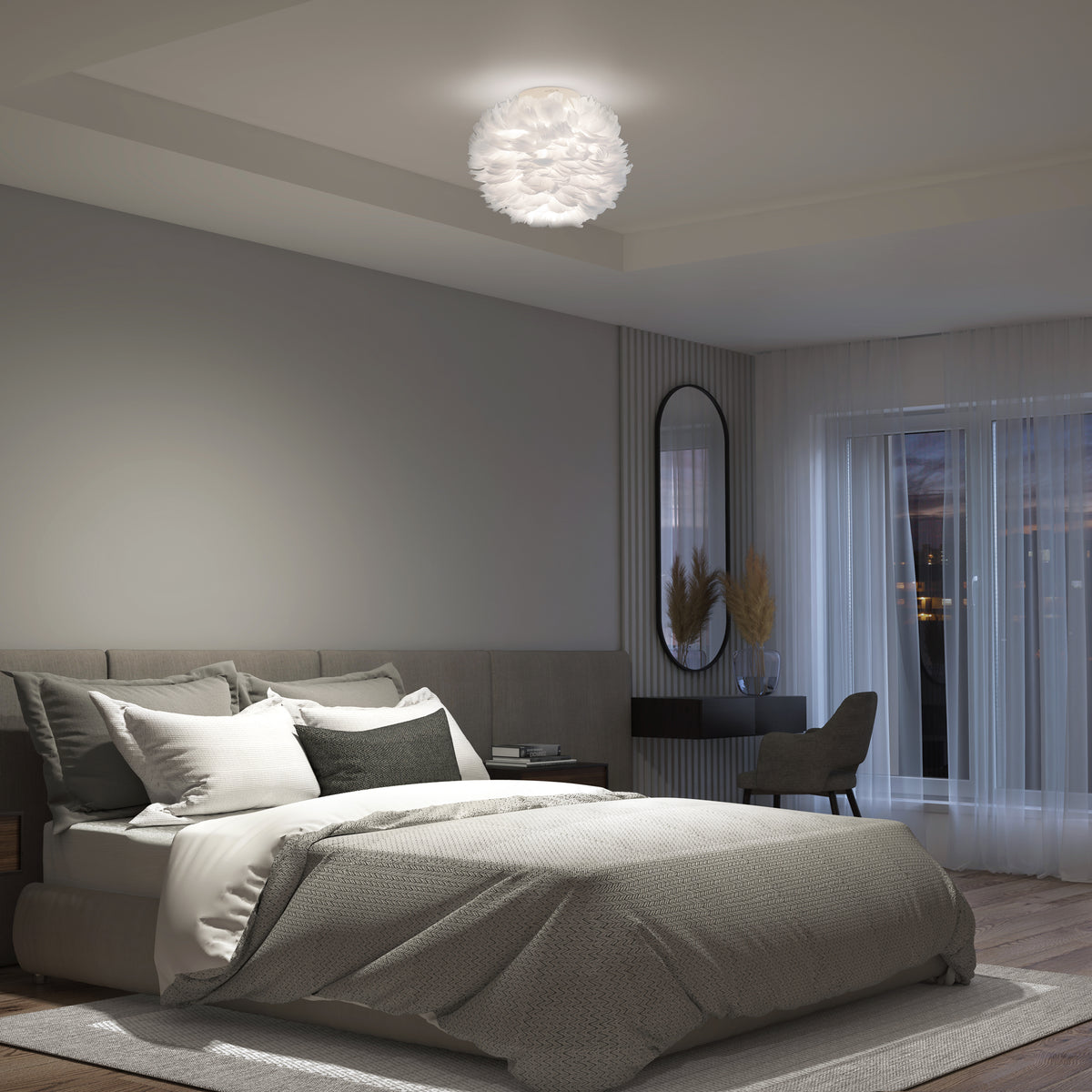 Modern bedroom featuring Artika’s Plume LED flush mount light, a large bed, neutral décor, desk and chair, oval mirror, and floor-to-ceiling windows with sheer curtains framing a dusk sky.
