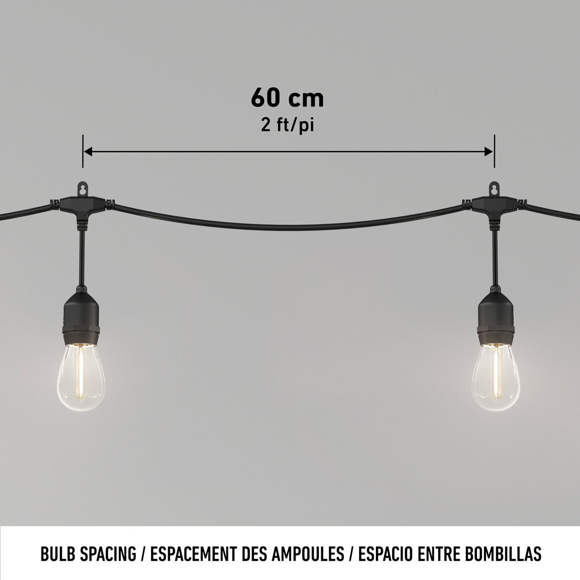 Two hanging light bulbs on a black string light set, spaced 60 cm (2 ft) apart, displayed against a plain background with measurement labels above the bulbs.