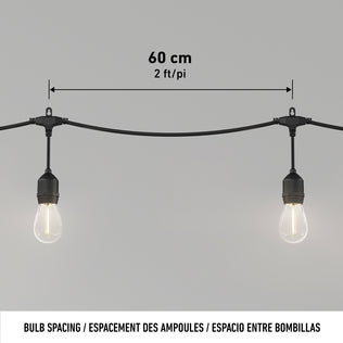 Two Blaze 20 LED Outdoor Solar String Lights by Artika hang from a black cord, spaced 60 cm (2 ft) apart. The plain background shows the spacing labeled above the LEDs in both centimeters and feet.