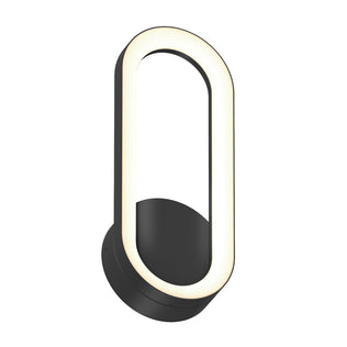 The Artika Aiden modern LED indoor-outdoor wall light 5 CCT features a black circular base and an elongated oval LED frame, emitting a soft warm white glow.