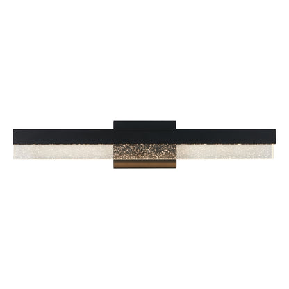The Artika Bubble Bar LED bathroom vanity light features a modern, wall-mounted design with a long black horizontal bar, a sparkling textured diffuser, and a central gold accent at its base.