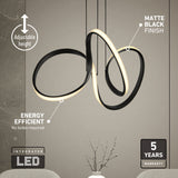 Modern sculptural pendant light with integrated LED, matte black finish, and adjustable height. Text highlights features: energy efficient, no bulbs required, 5-year warranty. Light hangs above a decorated table.
