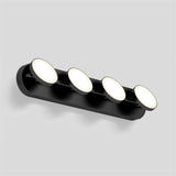 A modern black wall light fixture with four round, illuminated LED panels arranged in a row, mounted on a neutral grey background.