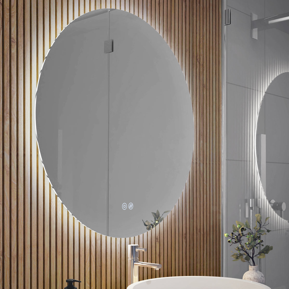 Mounted on a wall with vertical wooden slats is the Artika Raya 24 in. LED mirror (3 CCT, defogger). Below sits a modern sink with silver faucet, soap dispenser, and a small plant—a stylish bathroom setup.
