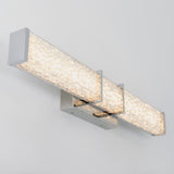 A modern wall-mounted LED light fixture with three rectangular, crystal-embedded bars emitting a bright, white glow, attached to a metallic base on a white wall.
