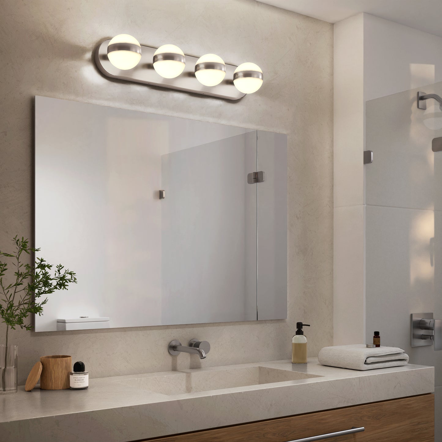 Modern bathroom featuring the Artika Baldric LED modern bathroom vanity light 3 CCT above a large rectangular mirror, with a wall-mounted faucet, soap dispenser, towel, and small plant on a light-colored countertop.