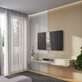 A modern living room with a wall-mounted TV on a wood slat accent wall, a floating shelf with decor items, a potted plant, large window with sheer curtains, and a gray area rug.