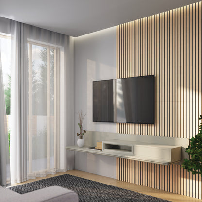 A modern living room with a wall-mounted TV on a wood slat accent wall, a floating shelf with decor items, a potted plant, large window with sheer curtains, and a gray area rug.