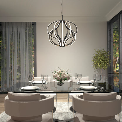 A modern dining room with a glass table set for four, beige cushioned chairs, a floral centerpiece, large windows with sheer curtains, a potted plant, and the Meridian LED pendant light by Artika hanging overhead.