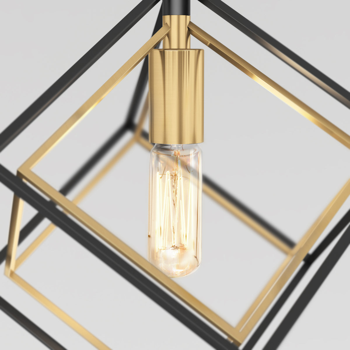 The Artika Imperium Single pendant light features a glowing exposed bulb within intersecting gold and black geometric metal frames, set against a plain light gray background.