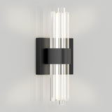 A modern wall sconce with a black rectangular base and central band, featuring vertical glass rods on both sides that diffuse the light, mounted on a light grey wall.