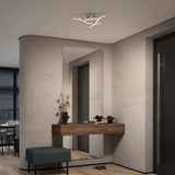 Modern hallway with a floating wooden console table, decorative vases, and ornaments. A teal bench sits below, a large mirror is on the wall, and a contemporary ceiling light fixture is overhead.