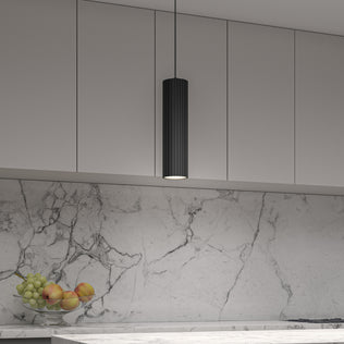 A modern kitchen with light gray cabinets, a marble backsplash, an Artika Groove LED modern pendant light 3 CCT hanging from the ceiling, and a bowl of apples and grapes on a white countertop.