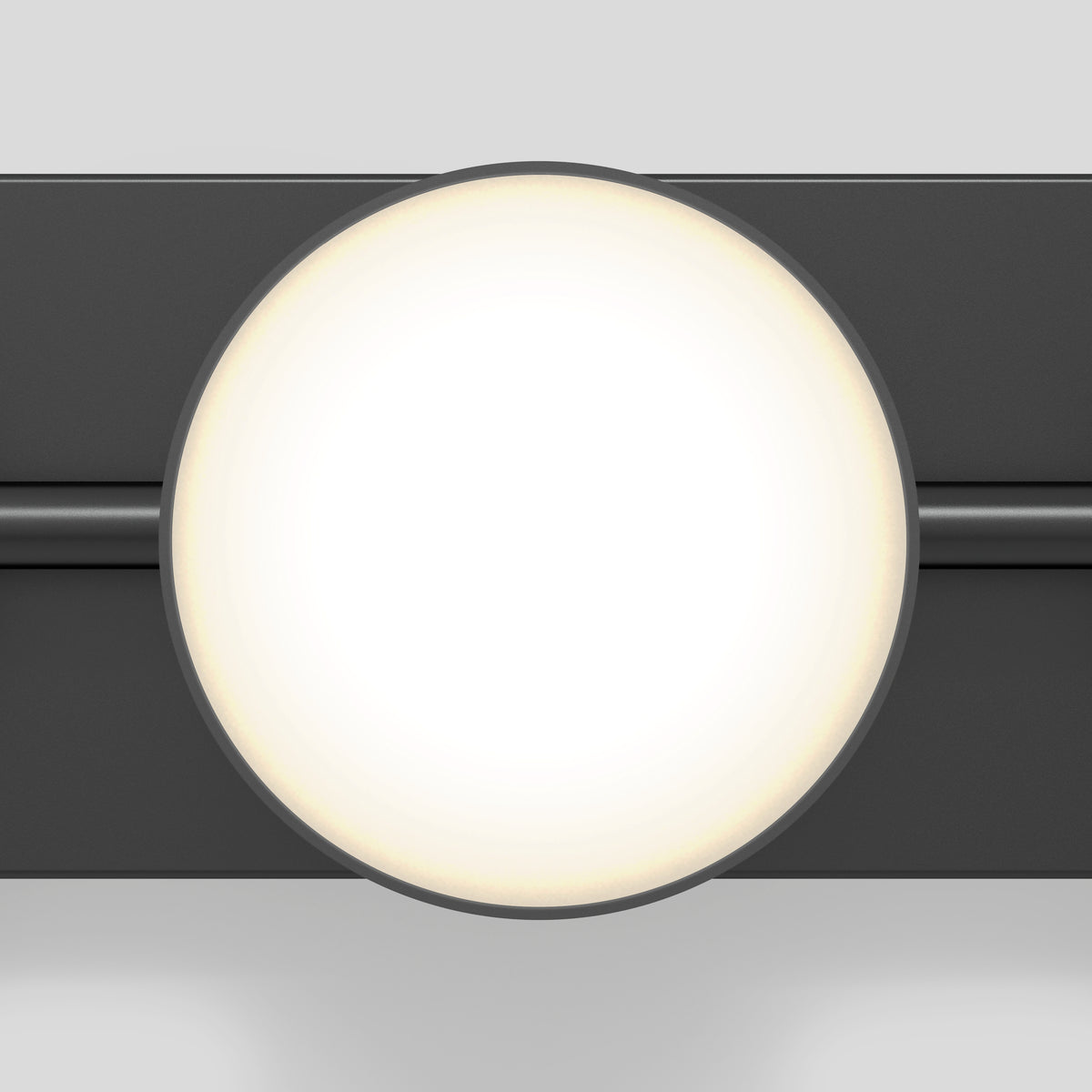 A round, bright white light fixture with a soft glow is mounted on a dark horizontal bar against a light gray background. The design appears modern and minimalistic.
