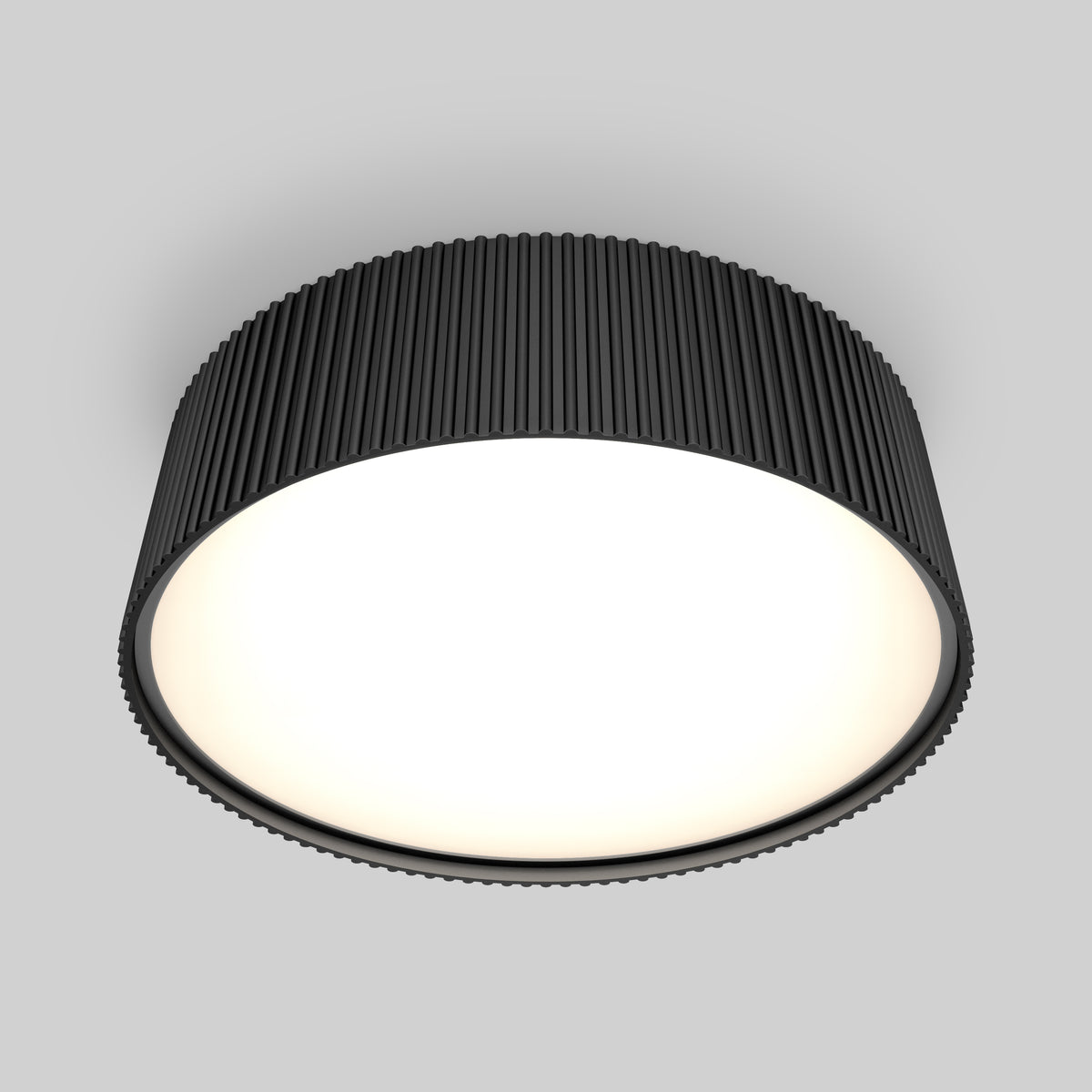 A modern, round ceiling light with a black ridged outer casing and a smooth, glowing white diffuser, mounted on a light gray ceiling.