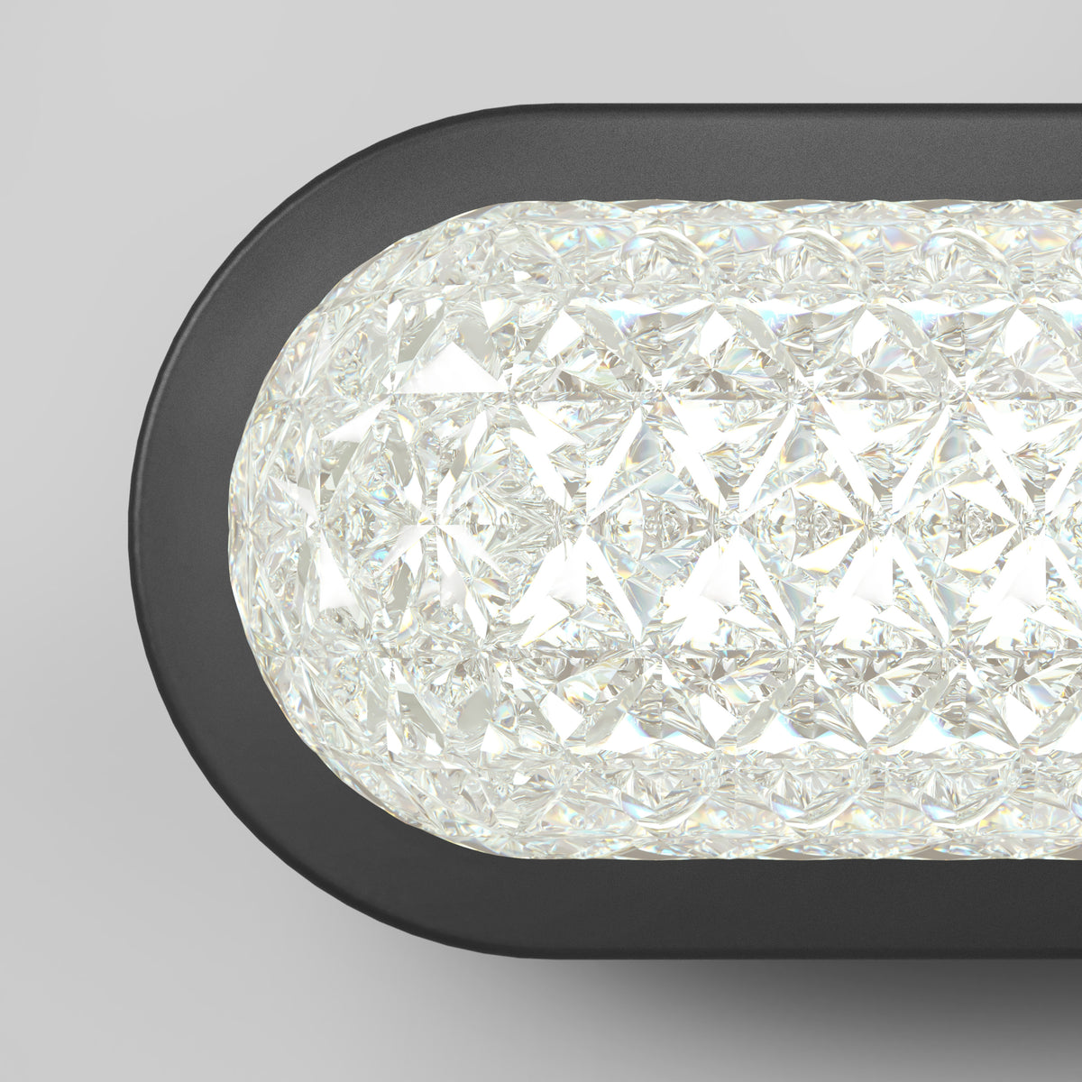 Close-up of a modern wall light fixture with a textured, diamond-patterned glass cover and a black frame, emitting bright white light against a plain gray background.