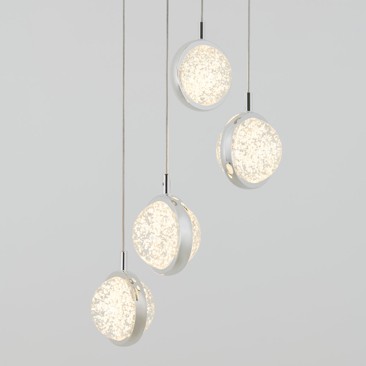 The Artika Avalon 4-light LED pendant features frosted, textured glass shades hanging at various heights against a light gray background, casting a soft, warm glow.