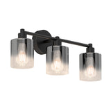 A modern wall-mounted light fixture with three exposed light bulbs, each enclosed in a cylindrical, smoky glass shade, attached to a horizontal black metal bar and round wall plate.