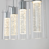 Close-up of modern hanging pendant lights with clear cylindrical glass shades, illuminated and featuring bubbles inside the glass, against a light, neutral background.