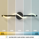 A modern wall light with a wavy design is shown emitting different white color temperatures, ranging from warm (2700K) on the left to cool (5000K) on the right, with labels and a selectable white light icon below.