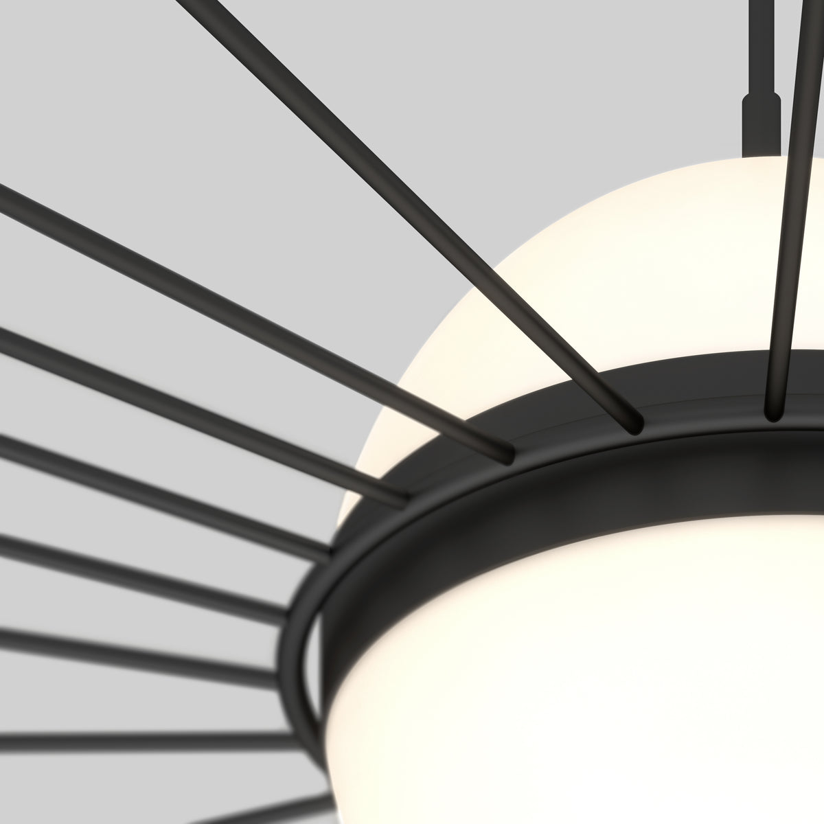 Close-up of a modern ceiling light fixture with a round frosted glass shade, featuring evenly spaced black metal spokes radiating outward against a light gray background.