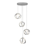 Modern pendant light fixture with four intertwined circular LED lights, each hanging at different heights from a round, silver ceiling plate by thin cords. The design is sleek and contemporary.