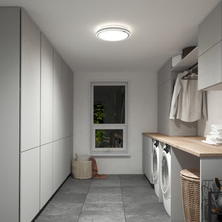 Modern laundry room with gray cabinets, wood countertop, washer and dryer, baskets, and hanging clothes. The Artika Altitude 15 in. LED modern flush mount light 5 CCT brightens the space alongside natural light from the window.