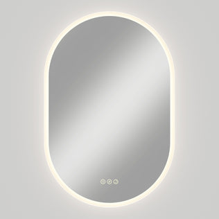 Artika Clara LED Mirror Oval 30x20 in. with defogger, 3CCT, soft backlight, and three touch buttons on a plain light gray wall.