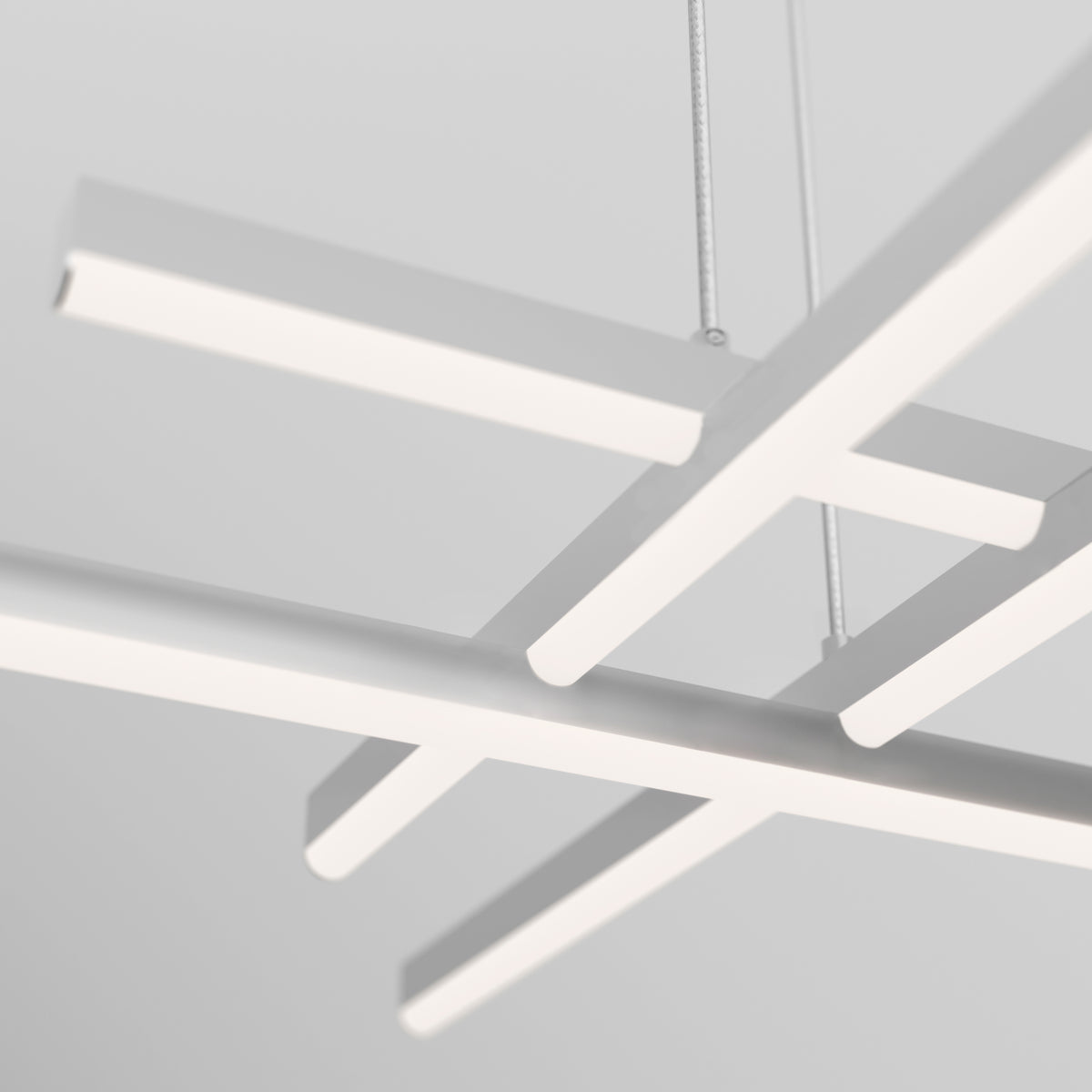 The Artika Grid modern LED pendant light 5 CCT hangs from the ceiling with minimalist white fixtures, featuring clean, straight lines and a geometric aesthetic against a light gray background.