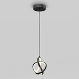 A modern pendant light with interlocking black rings and integrated LED lighting hangs from a ceiling on a black cord against a plain light gray background.