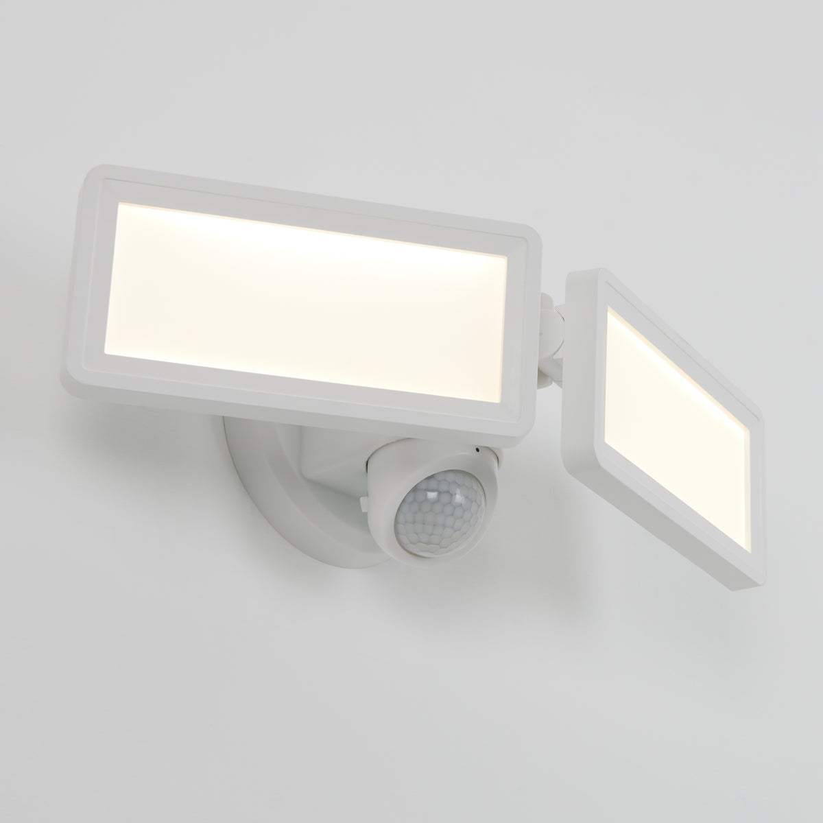 A white, wall-mounted LED security floodlight with two rectangular adjustable panels and a motion sensor beneath them, shown against a plain white background.