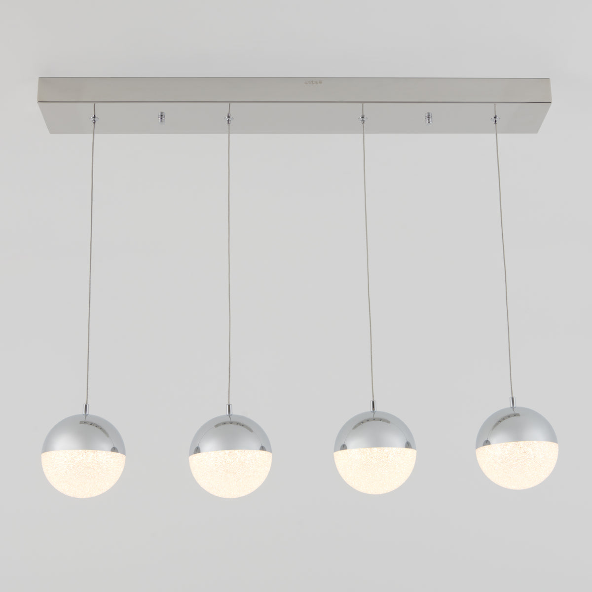 A modern ceiling light fixture with four suspended spherical lamps, each half chrome and half frosted white, hanging in a straight line from a rectangular metallic base.