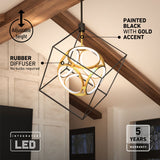 Modern geometric LED chandelier with a black cube frame, gold circular accents, and rubber diffusers hangs from a ceiling with wooden beams in a bright room. Text highlights features: adjustable height, 5-year warranty, and integrated LED.