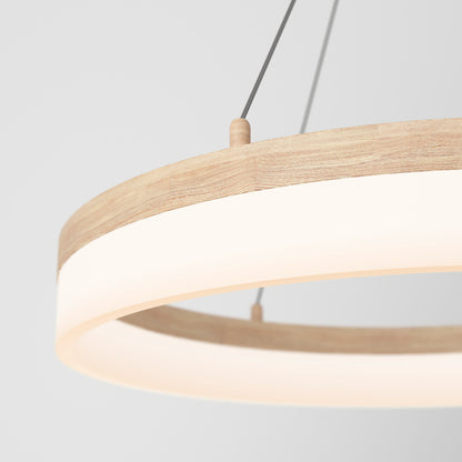 A close-up of the Artika Optical LED pendant light 3 CCT, featuring a minimalist wooden frame and frosted white diffuser, suspended by thin wires against a plain light background.