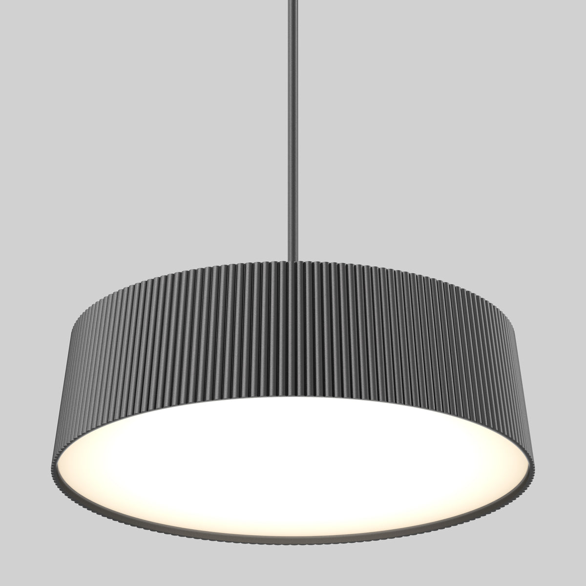 The Artika Groove Drum LED contemporary pendant light features a wide, cylindrical, dark gray ribbed shade and 3 CCT options, hanging from the ceiling and casting a bright, even glow against a plain gray background.