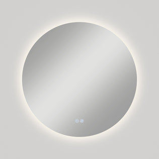 The Artika Raya 24 in. LED mirror features a modern round design, 3 CCT lighting with a glowing edge, built-in defogger, and two touch controls at the bottom center, shown mounted on a plain light-colored wall.