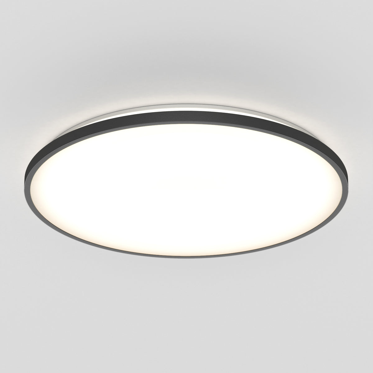 A round, modern ceiling light fixture with a black rim and a bright white illuminated center, mounted on a plain, light-colored ceiling.