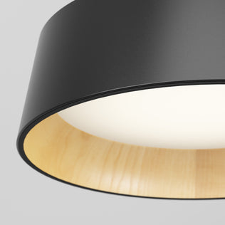 Close-up of the Alton modern LED pendant light 5 CCT by Artika, featuring a matte black exterior, light wooden interior, and a softly glowing white diffuser.