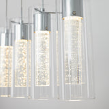 Close-up of modern pendant lights with cylindrical glass shades and chrome fittings, featuring inner tubes with tiny bubbles illuminated by bright LED bulbs against a light background.