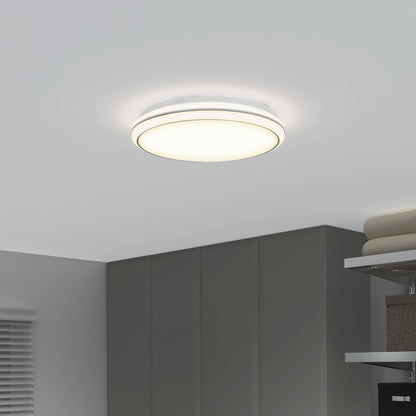 The Artika Emina 13 in. LED flush mount light (3 CCT) adds a soft, bright glow to a clean, minimalistic room with gray cabinets, window blinds, and neatly folded towels on the shelf.