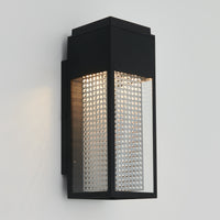 The Artika Meteor LED indoor-outdoor wall light features a modern black rectangular design with clear side panels and a perforated metal backplate, casting upward light against a light gray wall.