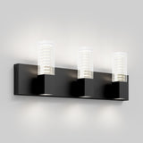 A modern wall sconce light fixture with three square black bases, each holding a clear rectangular glass shade, mounted on a matching black horizontal bar against a light grey wall.