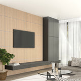 A modern living room with a wall-mounted TV on a light wood slat wall, sleek black cabinets, a glass coffee table, a gray sofa, a potted plant, and sheer white curtains over large windows.