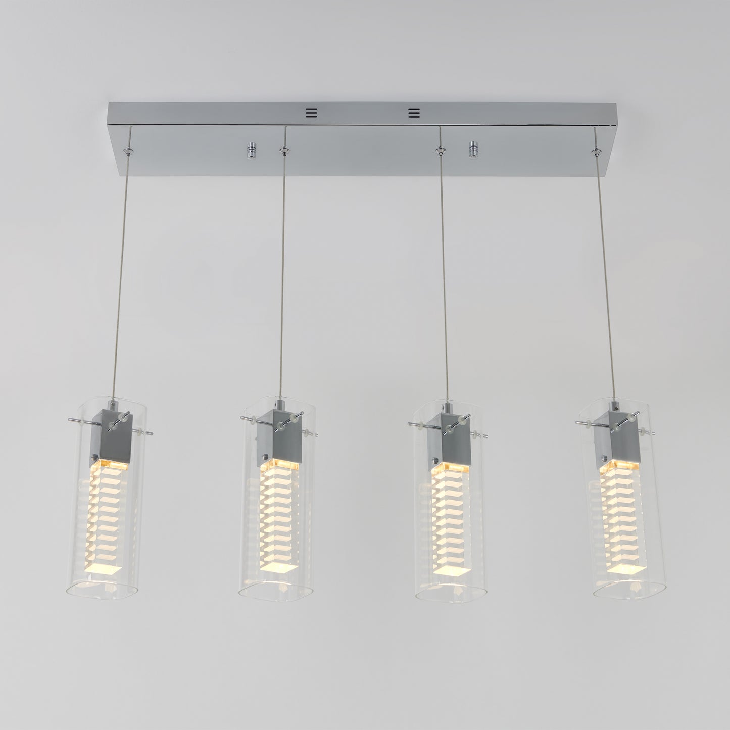 The Artika Hologram 4-light LED pendant features four cylindrical glass-shaded pendants with vertical LED bulbs, all suspended from a sleek rectangular chrome base.