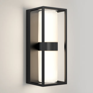 The Artika Sherman modern LED indoor-outdoor wall light 5 CCT features a rectangular black metal frame with a cylindrical white frosted glass, shown mounted on a plain light-colored wall.